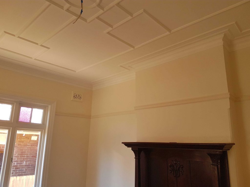 Federation-era room with moulded plaster ceiling panels, decorative cornice and timber mantel, completed by Sydney Wide Plastering