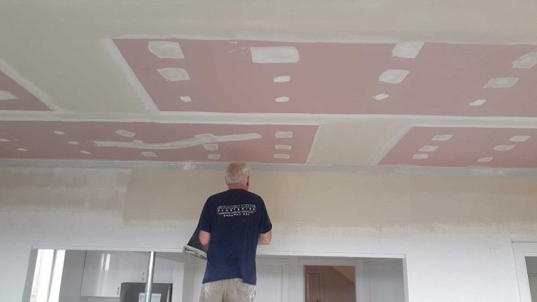 Plasterer setting out decorative coffered ceiling panels in a Sydney home