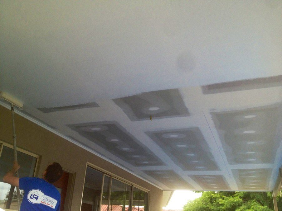Painter rolling a newly plastered ceiling